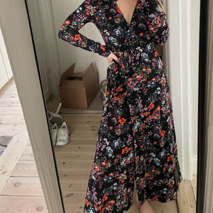Klänning Arket  - Säljer en jättefin svart och blommig klänning från arket. Endast använd en gång! Storlek 36. Väldigt skönt och lite ”tyngre” material så den faller otroligt fint. Knyts med ett snöre runt midjan som går omlott. 