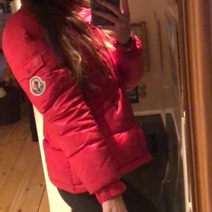 Moncler Maya Red - Köpt 2019 i NK Stockholm! Luvan är borttappad, men jackan är bra skick. Kan behövas tvättas då de finns en liten fläck vid fickan, men går att ta bort med kemtvätt! Kvittot finns även! Jackan är i strl 2 dvs S