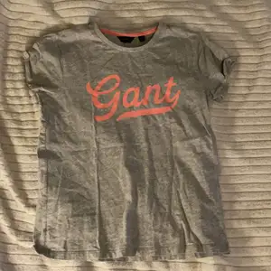 En grå Gant T-Shirt med rosa tryck. Storlek 158/164⚡️Nästan aldrig använd, 100% äkta Gant💞