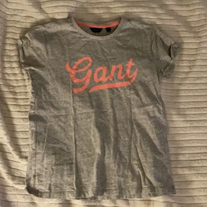 Grå Gant T-Shirt⚡️ - En grå Gant T-Shirt med rosa tryck. Storlek 158/164⚡️Nästan aldrig använd, 100% äkta Gant💞