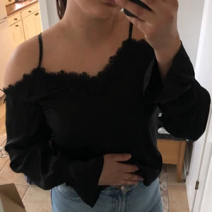 Blus - Snygg svart offshoulder blus med coola ärmar.