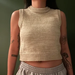 Beige-melerad stickad väst - mockneck, emelie malou x na-kd. så jävla söt men används ej längre. stickad, bra skick utan anmärkningar! frakt ej inkl i priset. 