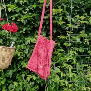 Rosa väska - Fin rosa väska med orientaliskt tema. Den har bjällror längsmed nederkanten och två tofsar i vardera hörn.  Kan både skicka spårbart och icke spårbart.