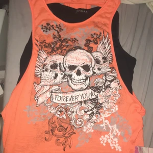 Döskalle tröja - Ett svart linne under med en orange tröja över med 3 olika döskallar på.