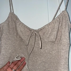 Klänning - Jättesöt ribbad grå-beige klänning med smala band. Går att reglera bandet framtill som knyts om man vill ha tightare eller lösarer över brösten. Oanvänd, endsst testad. utan tags tyvärr.  Såå söt men passar inte mig:( strl s! frakt ingår ej i priseeet