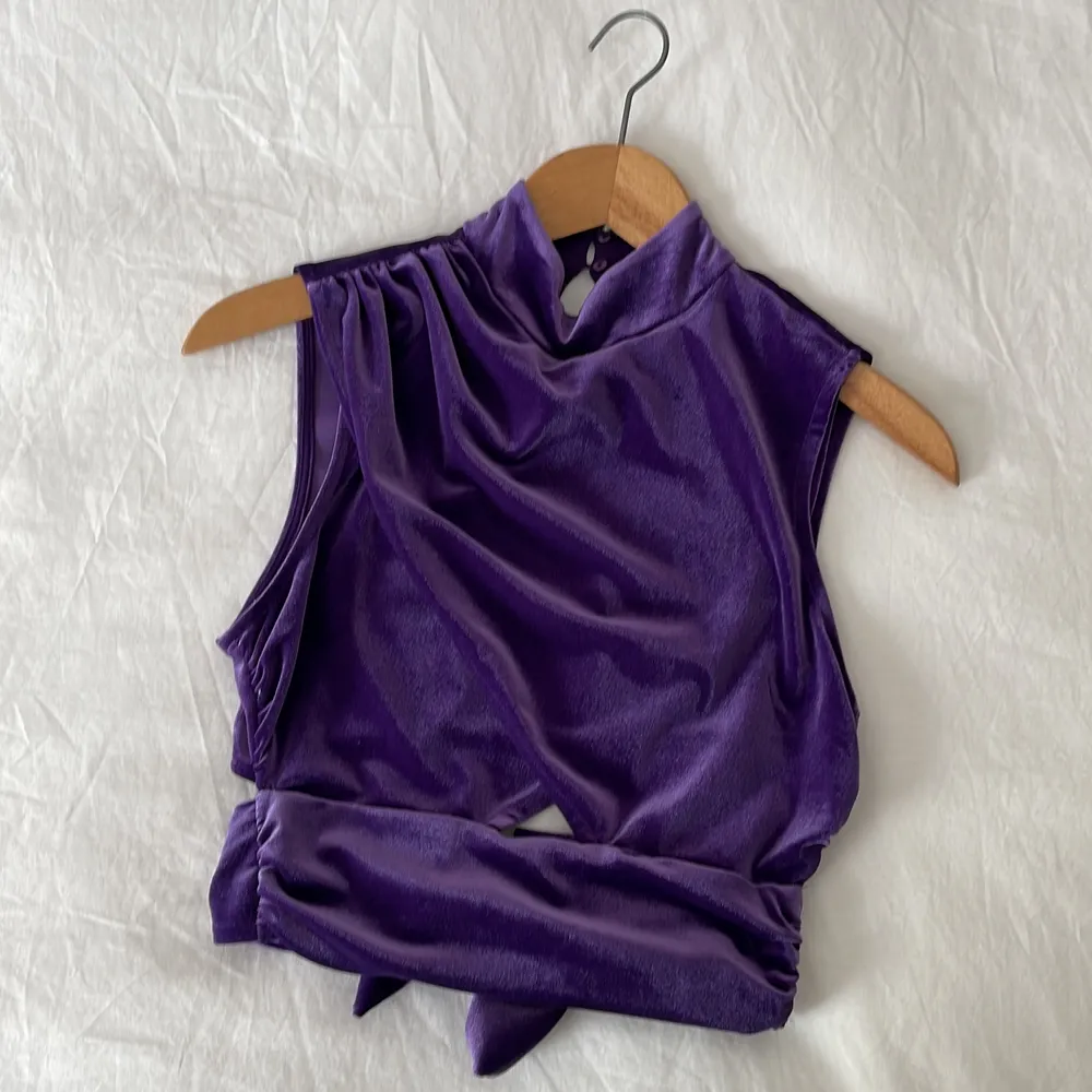 Gorgeous purple velvet top. With a tiny bit showing in the lower back and a little square peek from the belly as shown in pictures. Never worn. Suits xs as well but is an s. Toppar.