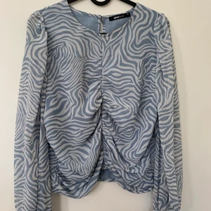 Mönstrad blus  - Blåvit mönstrad blus från Gina Tricot, strl 40. Sitter lite för löst i midjan/över bysten på mig som vanligtvis är mellan 38/40. Dragkedja på sidan och knapp i ryggen som skulle vara väldigt fin nu i sommar!!