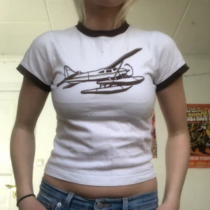 Babytee  - Gullig vit babytee med ett flygplan på! Färgerna är vit, brun, svart och grön! 💖💖💖