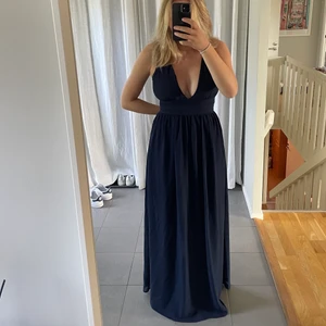 Balklänning - Balklänning med djup urringning samt rosett i ryggen. Lång på mig som är 173. Använd en gång, som nyskick