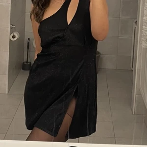 Glittrig klänning  - Glittrig klänning med slits 