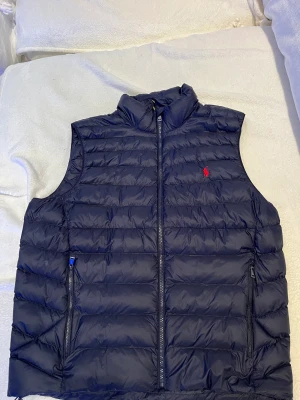 Polo Ralph lauren Väst - Helt oanvänd marinblå väst från Polo Ralph lauren skick 10/10. Lägger upp för jag inte använder den alls, nypris 2500 bud startar från 500.