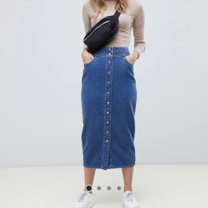 Mellanblå midikjol i denim med tryckknappar  - Köpts 2019 för 400. Den är i bra skick 