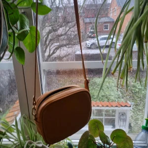 Senapsgul axelremsväska - Säljer en senapsgul axelremsväska. Köpt på monki för några år sen. Använt ett fåtal gånger men har hängt i garderoben i några år och aldrig använts. Säljer för 50kr + frakt.💕