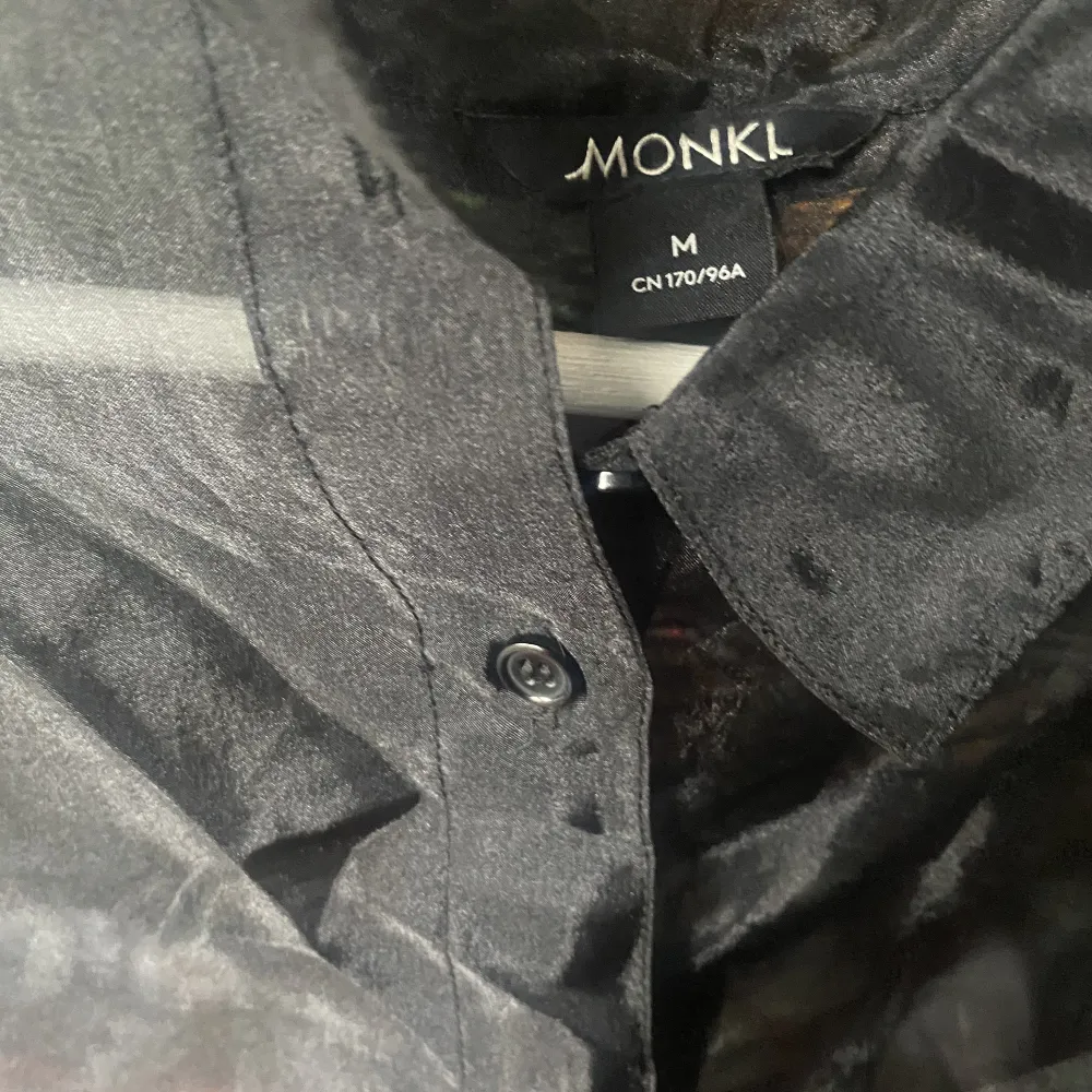 Jättefin svart skjorta från Monki, i organzamaterial. Genomskinlig och har lite oversize passform. Perfekt till nyår! Storlek Medium. . Skjortor.