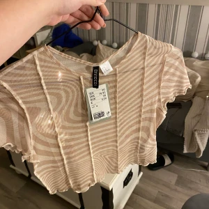 Topp - Säljer denna helt nya mesh topp, strl M! Prislapp kvar! Köpt på H&M för 99kr!  Frakt ~ 45kr