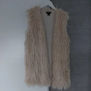 Pälsväst  - Pälsväst super snygg över en skinnjacka tex, är vit,beige snygg 
