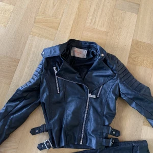 Bikerjacka strl s - Svart bikerjacka i strl S men mer än xs och strl. I fint skick och inte mycket använd. 