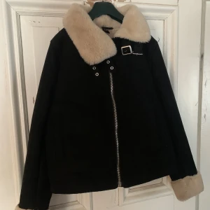 Vinterjacka med fakepäls- och mocka - Jackan är fodrad med fakepäls, även i ärmarna. Utsidan är mockaimitation med spännen upp till och har fickor i fram.  Använd endast ett fåtal gånger och är i väldigt bra skick. Köpt för ca 399kr. Säljer för att den ej används.  Köpare står för frakten.  