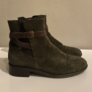Boots i grön mocka - Boots/jodhpurs i grön mocka. Fodrade, vilket klarar lite kallare väder. Endast använda 2 ggr. Storlek 39. Något liten i storleken så skulle säga 38-39. Ordinarie pris: 1249kr