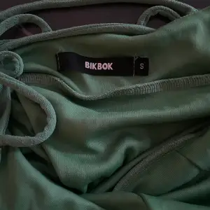 Grön klänning från Bikbok strl S, använd 1 gång. Väldigt stretchigt material så passar även M. Fin snörning i ryggen och grönare i verkligheten än på bild. Köparen står för frakt🌻