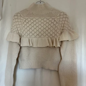 Stickad tröja med volang  - Stickad tröja med volang som jag tidigare köpt på tise av Therese. Tröjan är i Onesize men skulle säga att den passar S/M. Använd ca 1-2 gånger. 