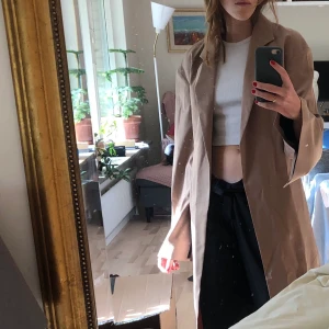 Filippa K - Superfin beige kappa från Filippa K, perfekt nu till hösten! Köpt på Sellpy för 600kr säljer då den tyvärr ej kommer till användning. Fint skick, på mig som är 170cm går den en bit över knäna. Skriv för fler bilder!🥰