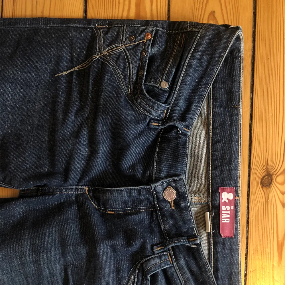 Mörkblå lågmidjade jeans med fina detaljer! Jättebra skick❤️ Jag är 161cm och de är väldigt långa på mig. Midjemått: 85cm Innerbenslängd: 85cm Använder ej funktionen frakt 63kr❗️. Jeans & Byxor.