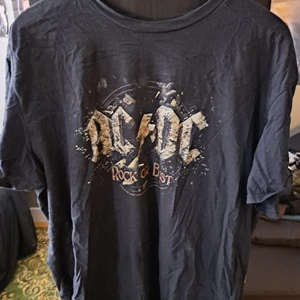 Acdc band tshirt - Nästan helt ny tshirt. Acdc. Köpte den i för liten storlek så därför använder jag den aldrig. Skulle säga att den är en storlek l inte xl. Beige gult tryck fram med svart baksida