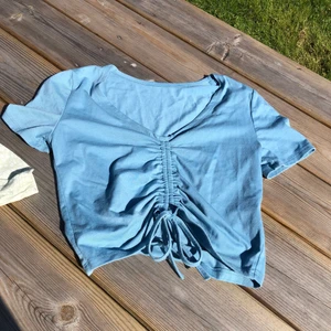 Blå topp - En söt blå v-ringad topp med knyte. Köpt här på plick men säljer nu vidare då deninte används. 