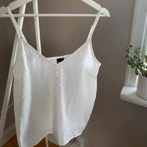 Vitt linne från GinaTricot i strl 38 - Vitt enkelt linne med dekorativa knappar från GinaTricot i storlek 38. Inga anmärkningar.  SKICKAS med postnords fraktpåse för 45kr, önskas spårbart tillkommer det.