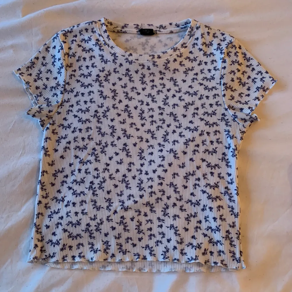 the cutest blue and white top from urban outfitters in size M, with tiny blue flowers and scalloped hems, perfect for spring and summer! 💙🤍. Toppar.