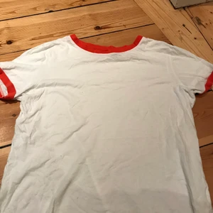 T-shirt  - Fin vit t-shirt med orange kant på halsen och armarna. Från bikbok i storlek s men passar även xs och xxs. Skriv för prutning, fler bilder eller köp!🧡🤍