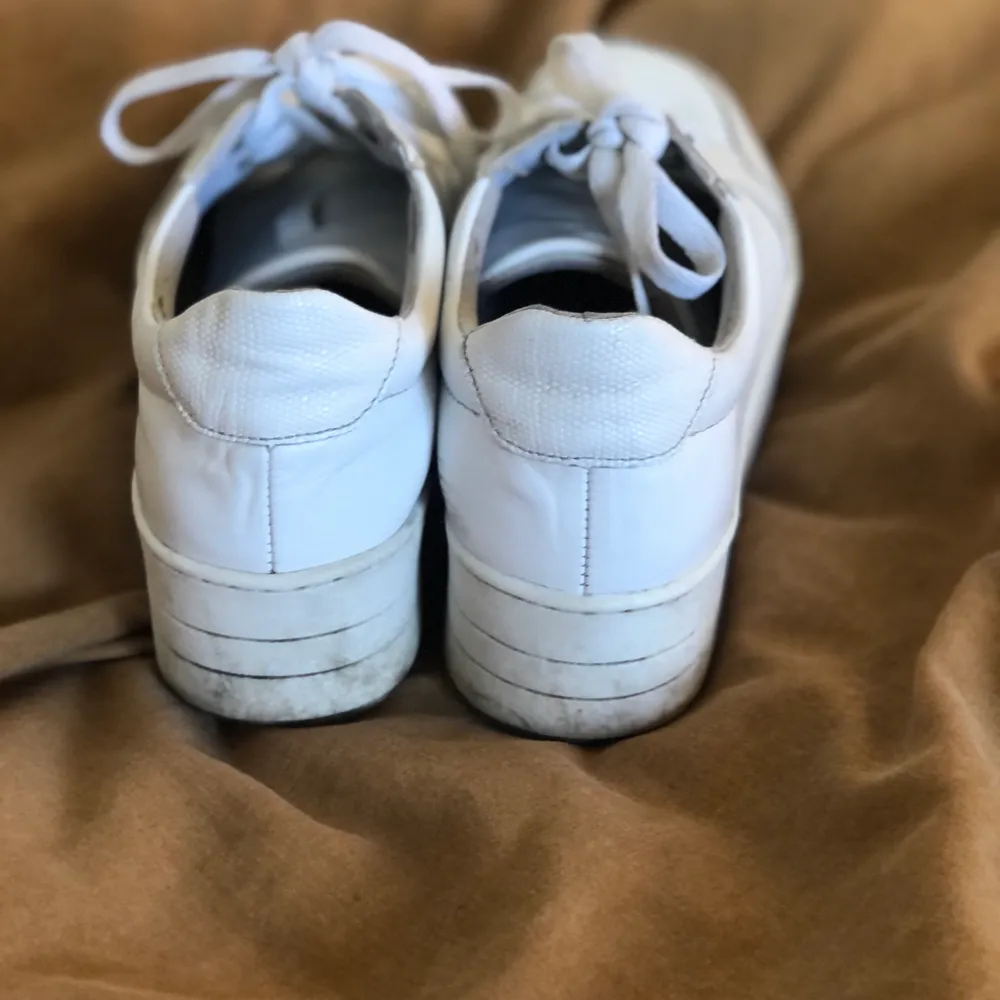 Vita sneakers med högra sula, använda i ett halvår men välbevarade. . Skor.