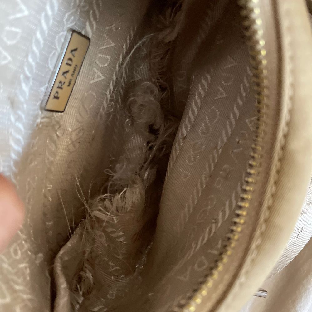 Prada re edition 2005 nylon bag in beige. Such a great bag! I love it. Selling for this cheap due to the torn lining, but not visible from the outside. Otherwise in great condition. . Some small stains on the back, I can send more pictures to you. . Väskor.