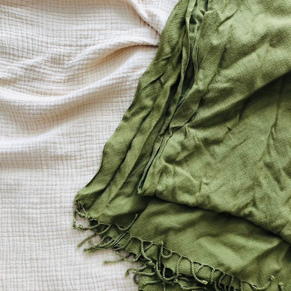 En grön sjal köpt secondhand och som kan knytas på olika sätt. Använd en gång av mig. Frakt ingår i priset💚. Toppar.