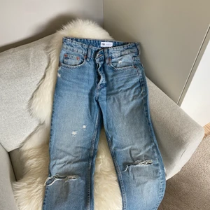 Blåa Mid Rise zara jeans med hål - Säljer dessa helt nya blåa Mid Rise jeans med hål och slitningar. Perfekta till sommaren och sitter supersnyggt. Kom privat för fler bilder. Pris kan diskuteras, men frakten ingår inte🎸🫶🏼 buda gärna 