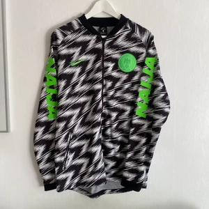 NIKE Autentic Football - NAIJA  - Rare collective item from Nike football. Nigeria Football Federation Abuja. Great condition. Dri-fit material. Pockets with zip. Size: L Length: 78cm Chest: 112cm 
