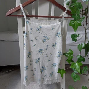 Blommigt sommarlinne med spetsdetaljer - Såå gullig och trendig topp med blommor och spetsdetaljer. Älskar den så mycket, men passar tyvärr inte🥲 Den är en anings nopprig, men jättefin ändå.