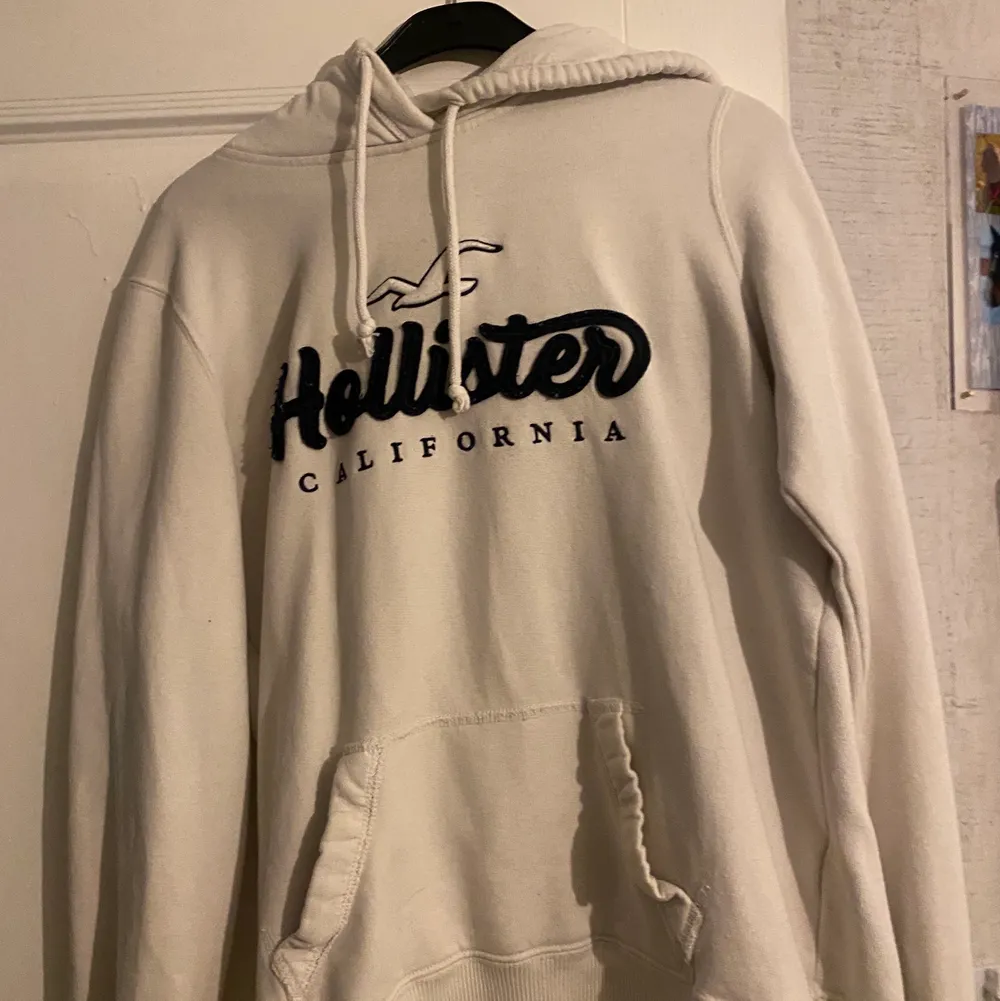 Vit hollister hoodie med marinblått tryck. Något nopprig, vilket syns på bilderna 💗. Hoodies.