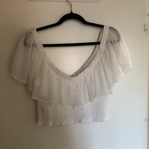 Sommartopp från Nelly - Fin och luftig sommartopp från Nly trend. Storlek 40. Använt skick men fin ändå. Resår runt om och en fin volang över.