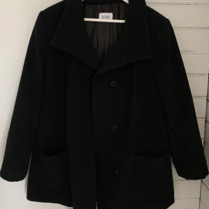 Svart kappa - Svart kappa i ett varmt material, skulle gissa på ull🤍 Köpt second hand och sitter oversized på mig som bär S/M☺️ Skriv för bilder med den på❣️