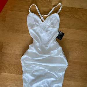 Vit Midi Klänning - Helt oanvänd klänning från Nelly. Klänningen är tight åtsittande och går strax över knäna, öppen rygg med snörning. 