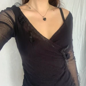 svart långärmad topp i mesh - superfin långärmad svart omlott-topp i mesh med blommor och rosetter från per una ～☆ lite men inte helt transparent, köpt second hand. lite liten i storlek (jag är storlek xs) men väldigt stretchiga så kan passa många<3 skriv för mått eller andra frågor! 