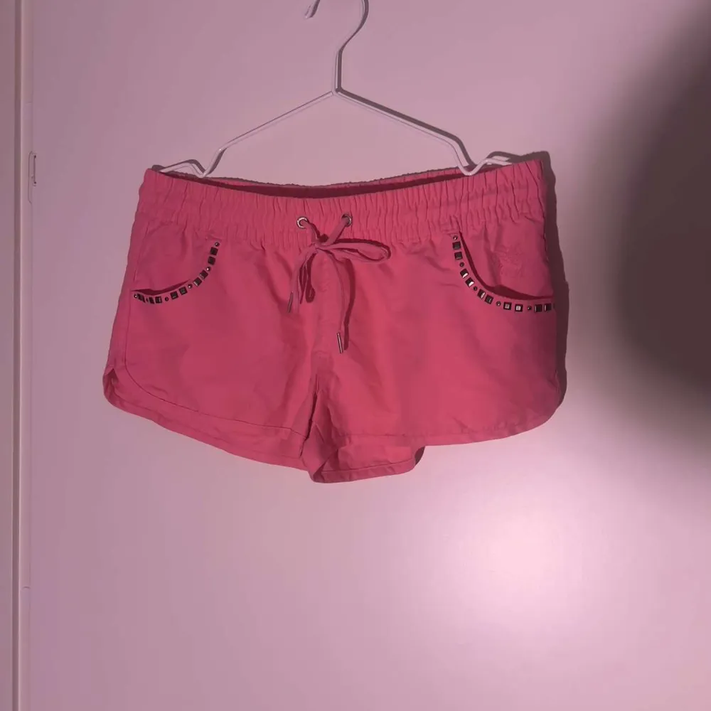 Oavdvända Neon rosa badbyxor med nit detaljer. Shorts.