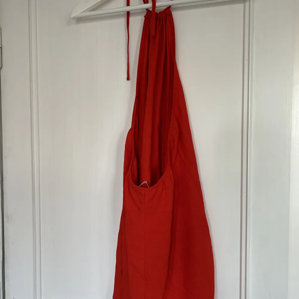 Säljer denna röda klänning med öppen rygg. Klänningen är bara använd ett fåtal gånger och i bra skick. Perfekt inför sommaren!. Klänningar.