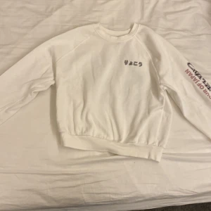 Vit TOUR OF JAPAN sweatshirt  - En snygg vit sweatshirt med japansk text på och med ett väldigt fint tryck med blommor på ryggen🤍🌸 Väldigt mjuk och skön att ha på sig🌸 TOUR OF JAPAN