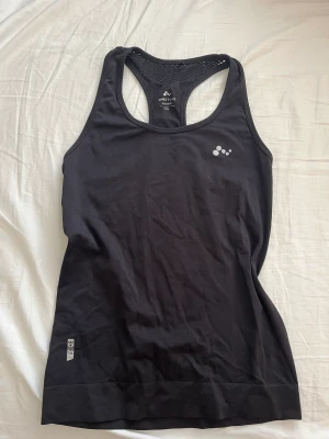 Träningslinne  - Ett svart snyggt tränings linne men snygg öppen rygg. Priset är exklusive frakt. 