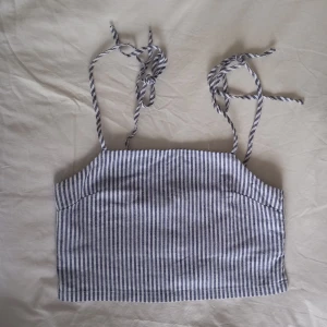 Linne - Blå/vit crop top modell med axelband som knyts. Passar xs-s