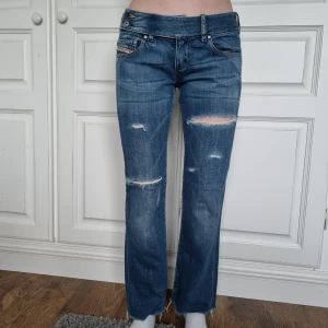 Lågmidjade Jeans - Supersnygga lågmidjade utsvängda byxor från Diesel. Väldigt fint skick. Vill man ha de längre i benen skulle dessa rekommenderas för någon med kortare ben.   Modellen på bild är 167 cm och brukar ha 25/32 eller 34 i strl.