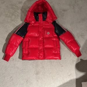 Röd,mörkblå vinter moncler jacka - Knappt använd ser typ ut som ny och är väldigt skön och varm att ha på sig. 